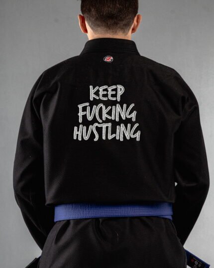 Keep Hustling embroidery on the back of a black BJJ Gi
