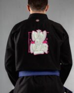 Now Or Never embroidery on the back of a black BJJ Gi