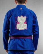 Now Or Never embroidery on the back of a blue BJJ Gi