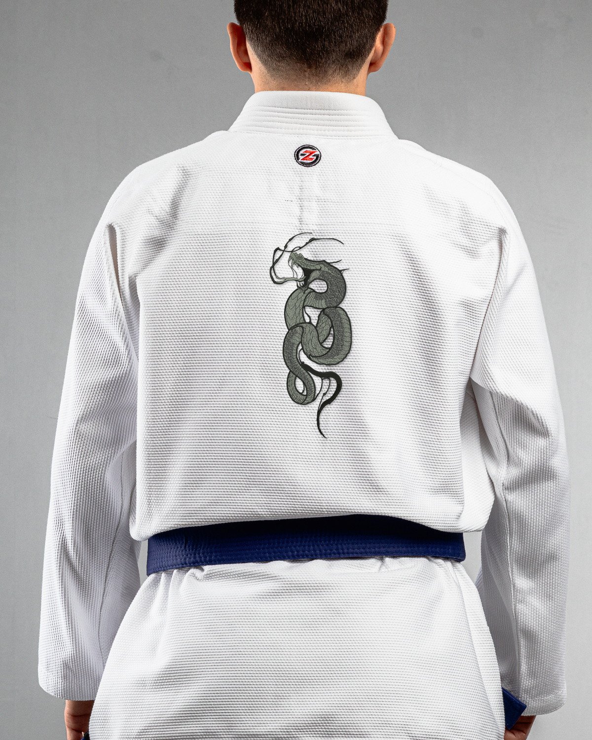 Snake Fangs white Gi back mockup Snake Fangs embroidery on the back of a white BJJ Gi